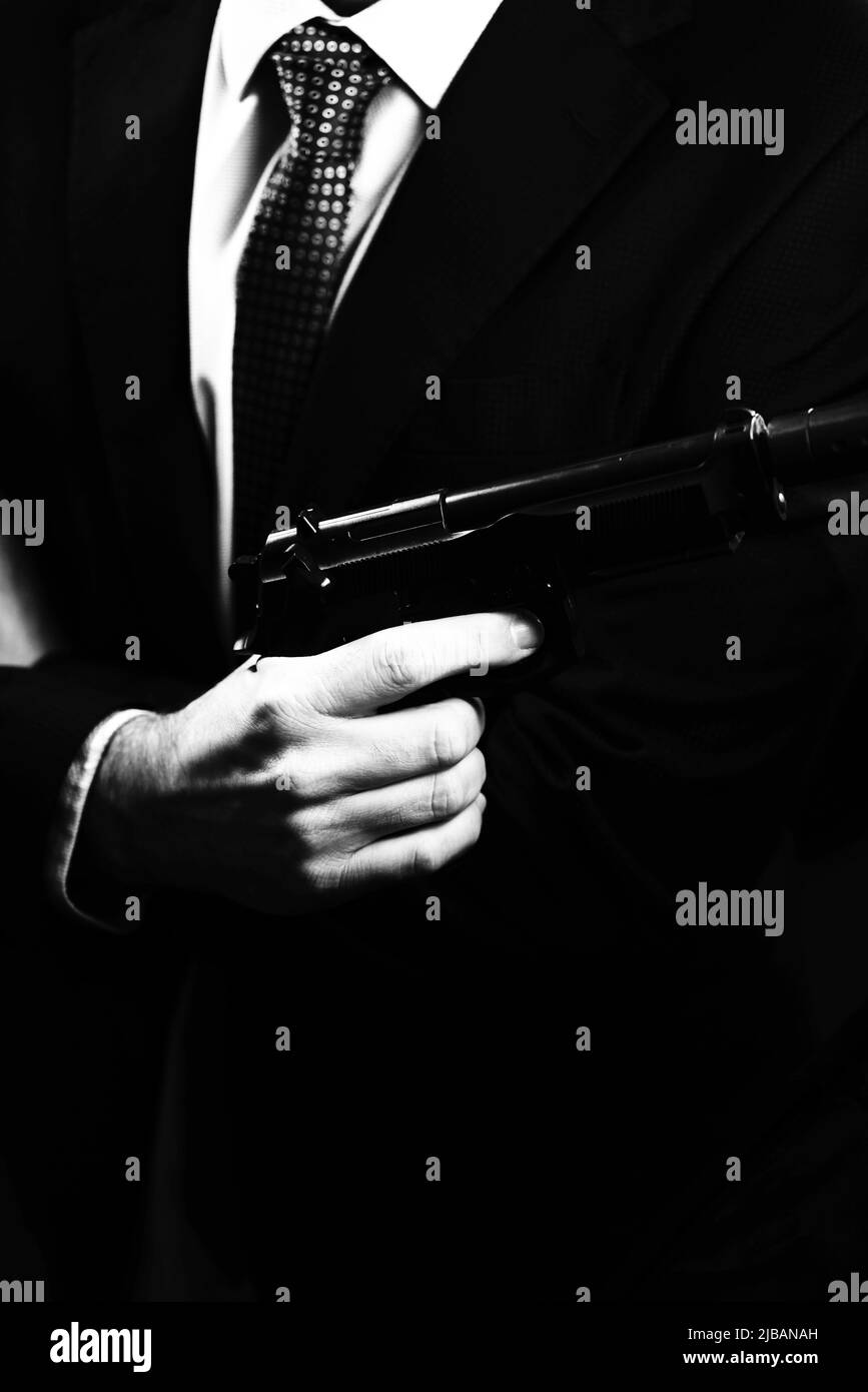 Bien vestido hombre secreto agente detective espía vestido traje y corbata  de sujeción de pistola automática Fotografía de stock - Alamy