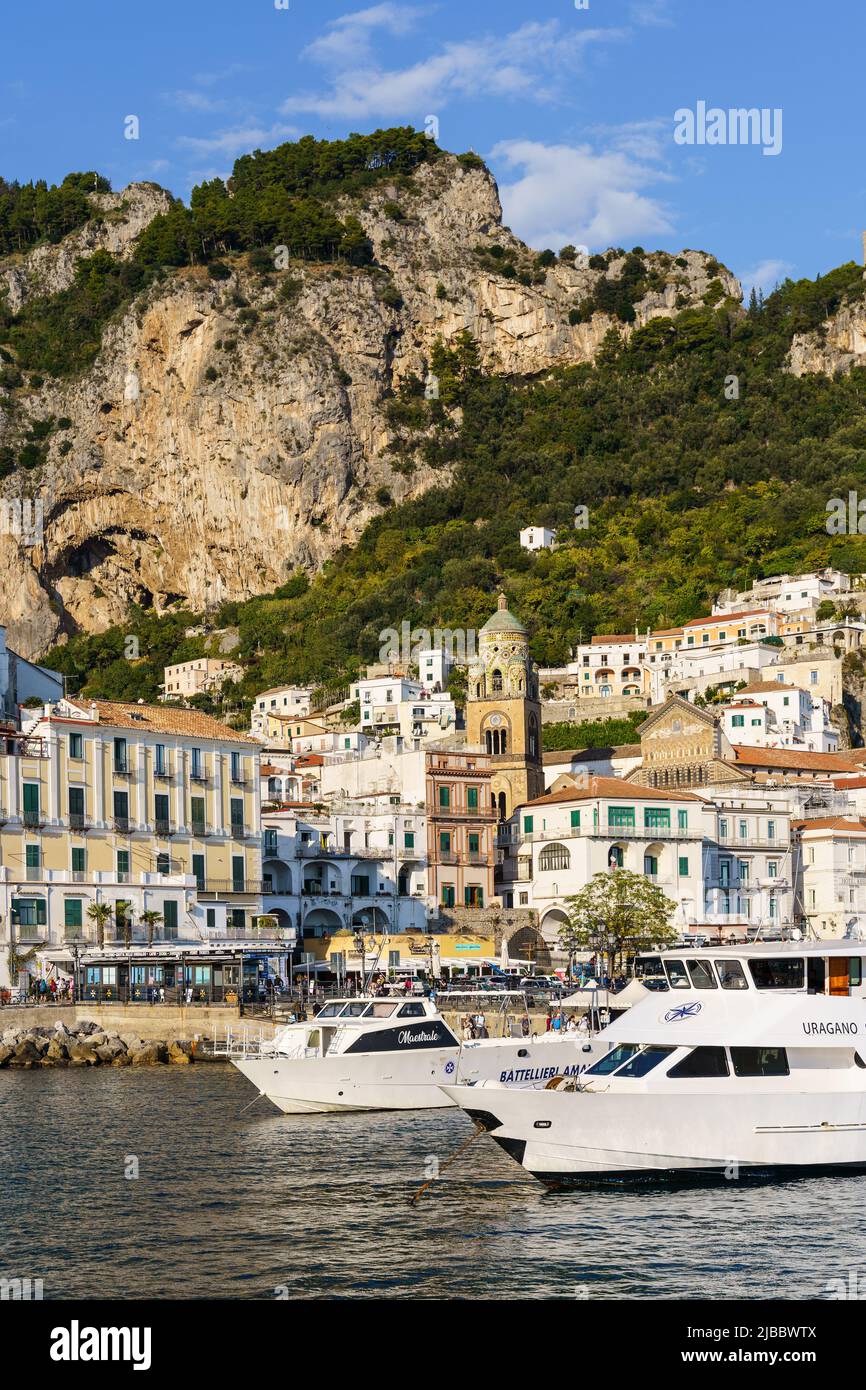 Amalfi, Italia - 18 2021 de octubre: Los barcos de turismo esperan al turista en frente de la famosa ciudad antigua de Amalfi con un espectacular acantilado en la región de Nápoles en Italia Foto de stock