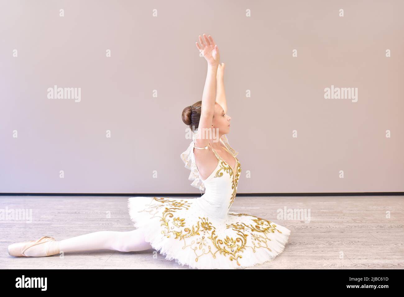 atractiva bailarina joven actuando hacia fuera. hermosa bailarina sentado hacia delante dividido Foto de stock