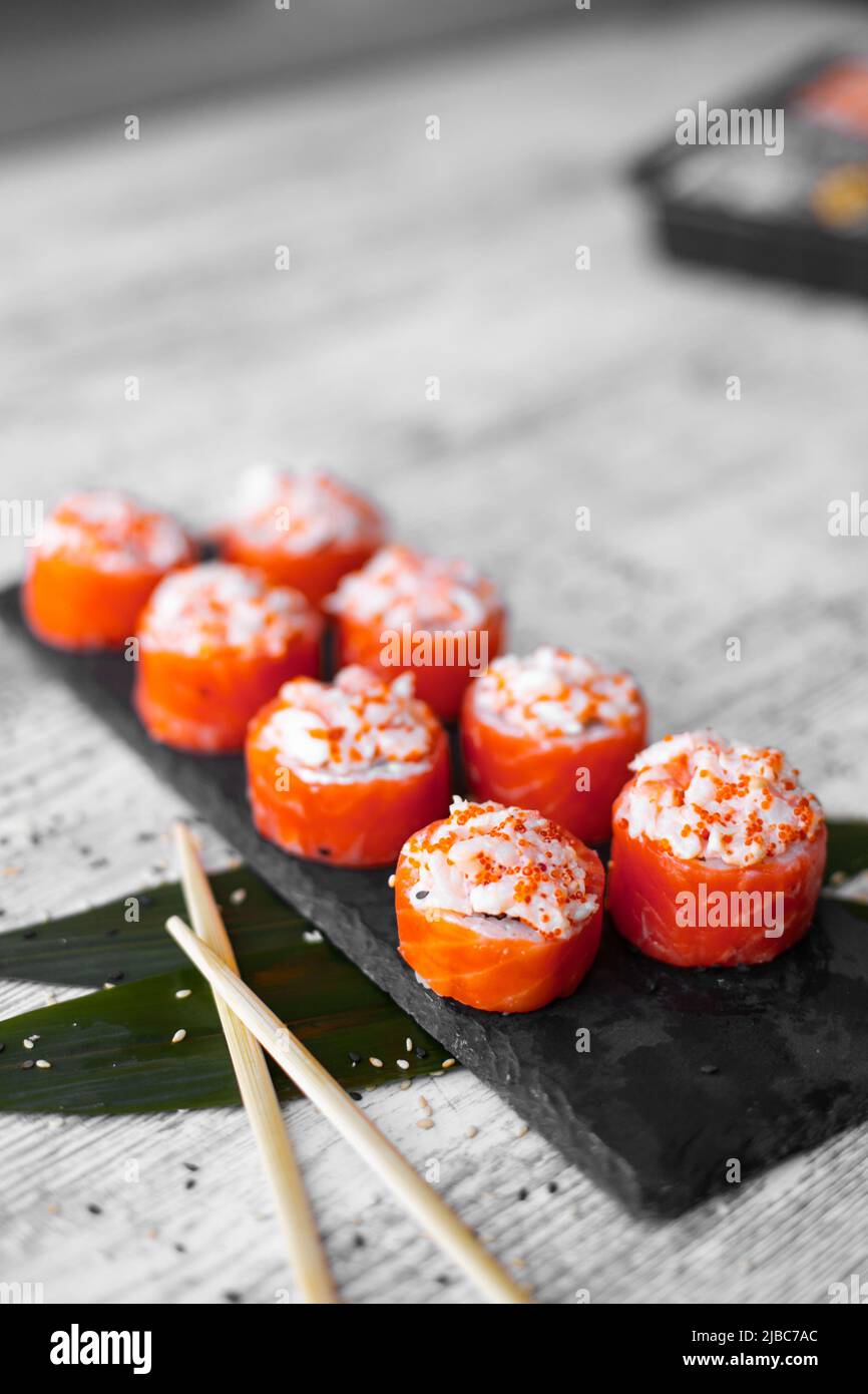 Juego de sushi nigiri y rollos de sushi en la vista superior del tablero de piedra negra Foto de stock