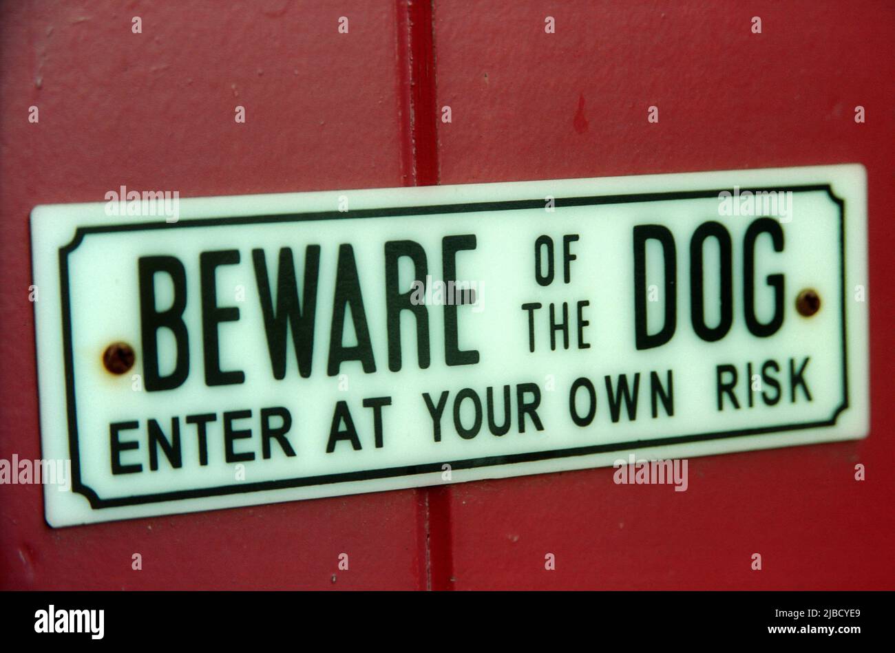 Ten cuidado con el letrero de perro y entra en aviso de riesgo propio Foto de stock