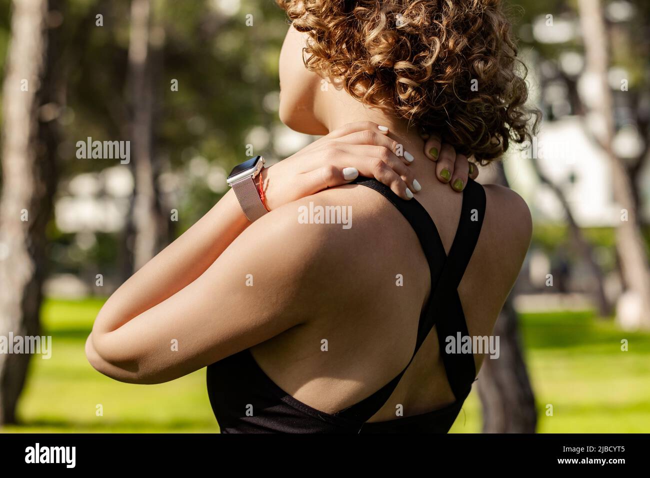 Mujer deportiva de pelirroja con sujetador deportivo negro de pie en el  parque de la ciudad, al aire libre sensación de dolor en la articulación  hombro espalda dolor, concepto de fibromialgia, clos