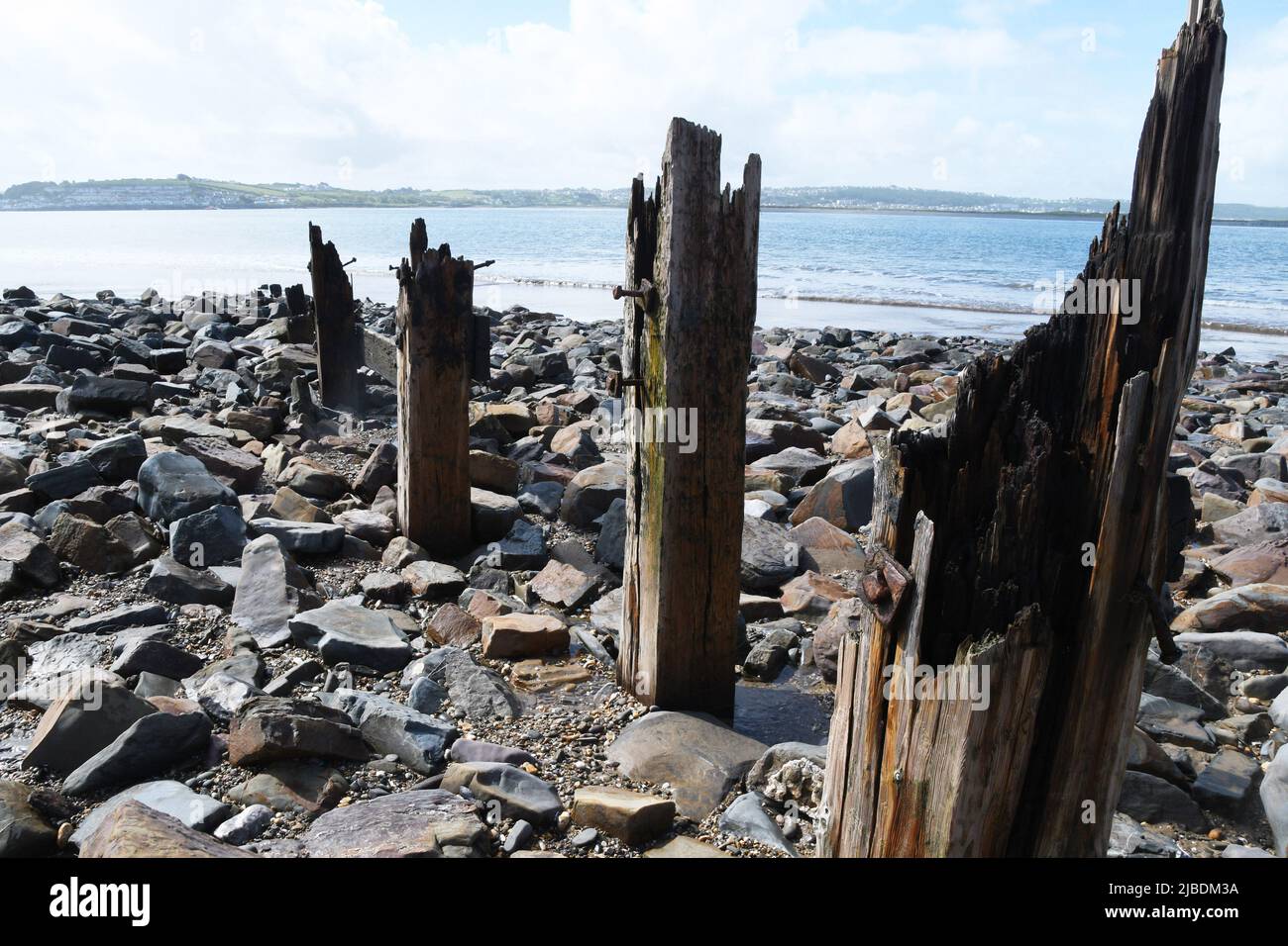 Postes de madera, los restos de los gromos en la playa, destruidos por el mar en la costa norte de Devon entre el sistema de dunas de Braunton Burrows. Vista Foto de stock