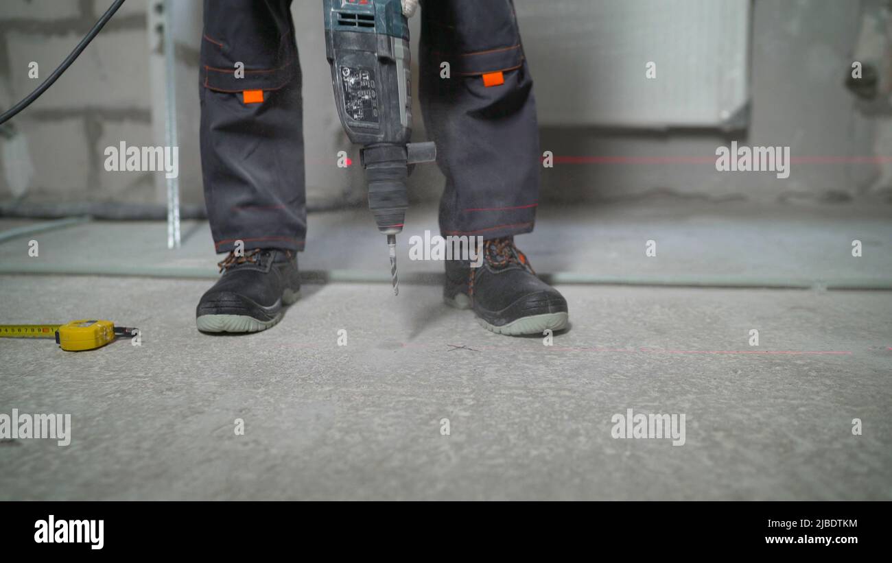 Taladro, suelo de hormigón, trabajador. El trabajador perfora un suelo de  hormigón Fotografía de stock - Alamy