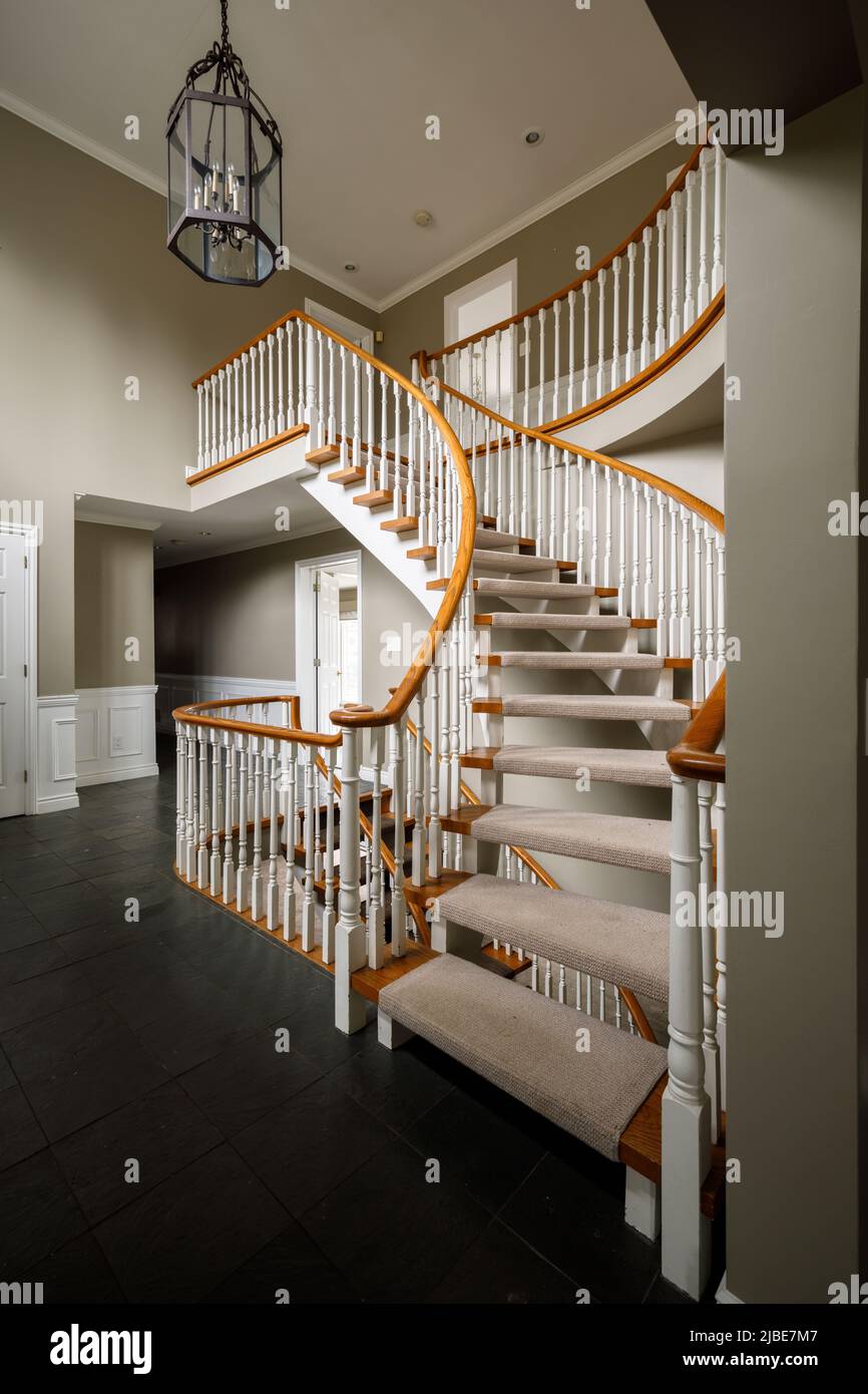 Una escalera curva dentro de una casa. Esta casa ha sido demolida desde entonces. Foto de stock