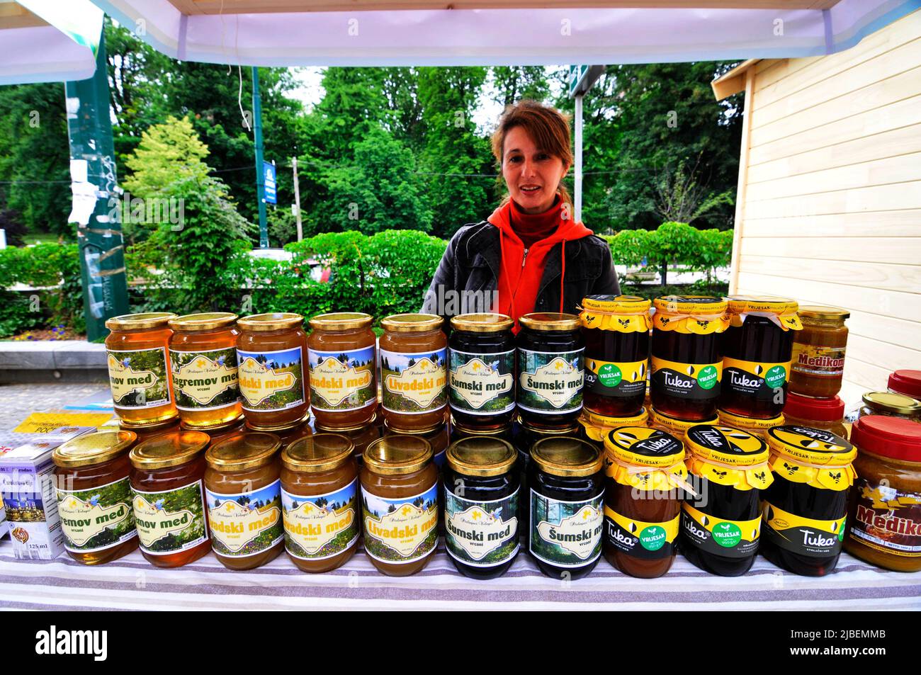 Una bosnia que vende miel bosnia en el Trg djece Sarajeva cerca del centro BBI en Sarajevo, Bosnia y Herzegovina. Foto de stock