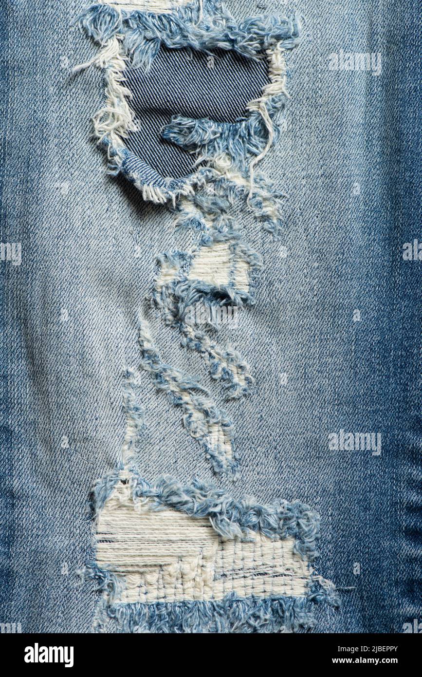 Detalle de primer plano de jeans azules rasgados. Textura vaquera
