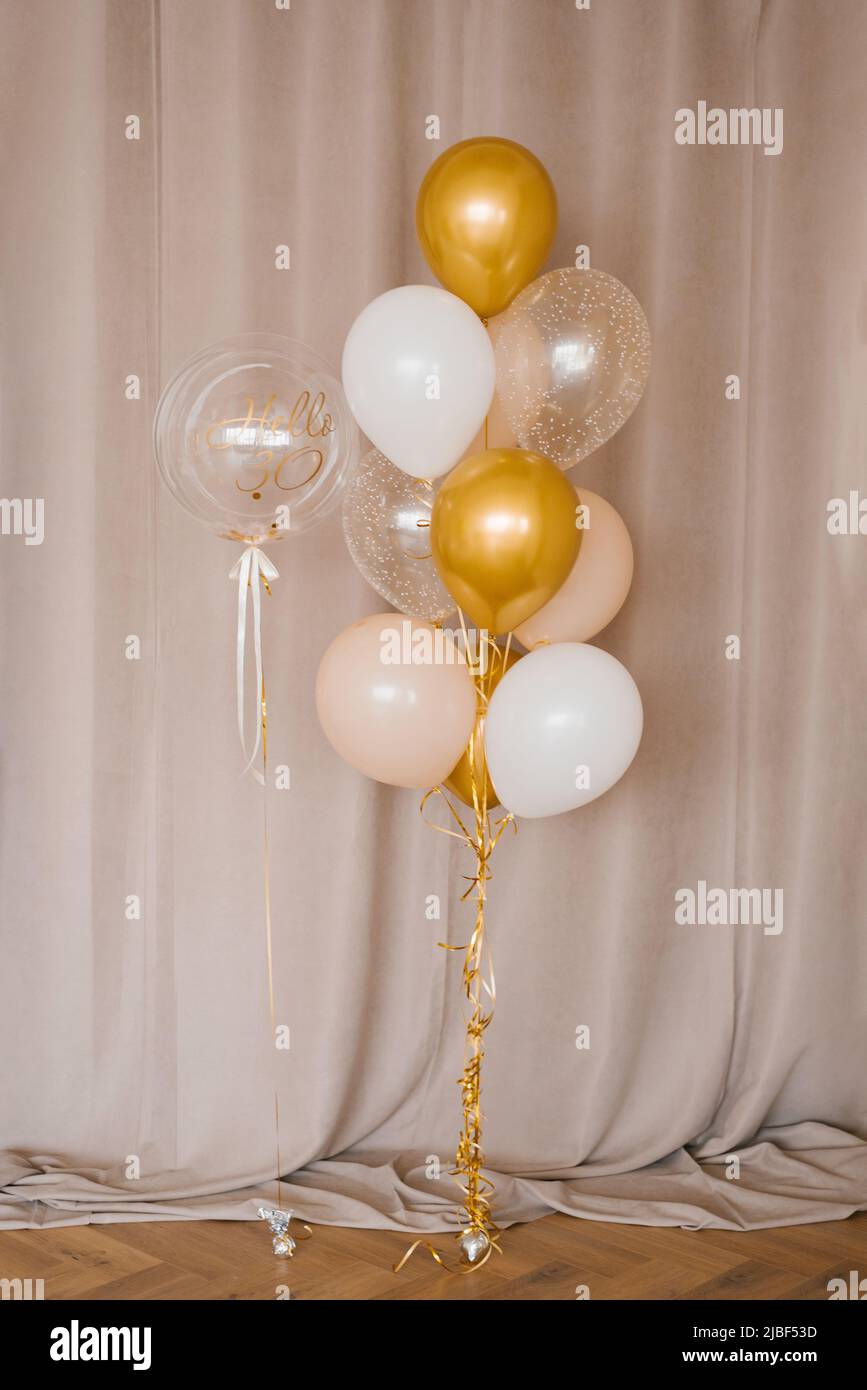 Decoración para cumpleaños, aniversarios, globos, luces en una pared. Globos  dorados y plateados Fotografía de stock - Alamy