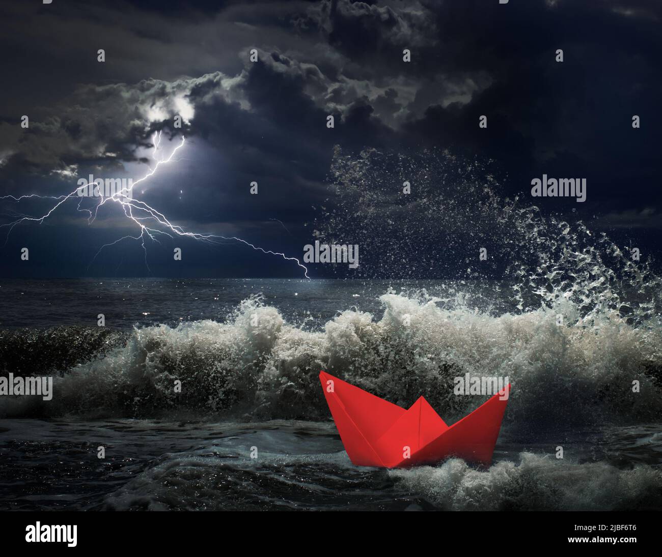 Barco de papel rojo en concepto de tormenta Foto de stock