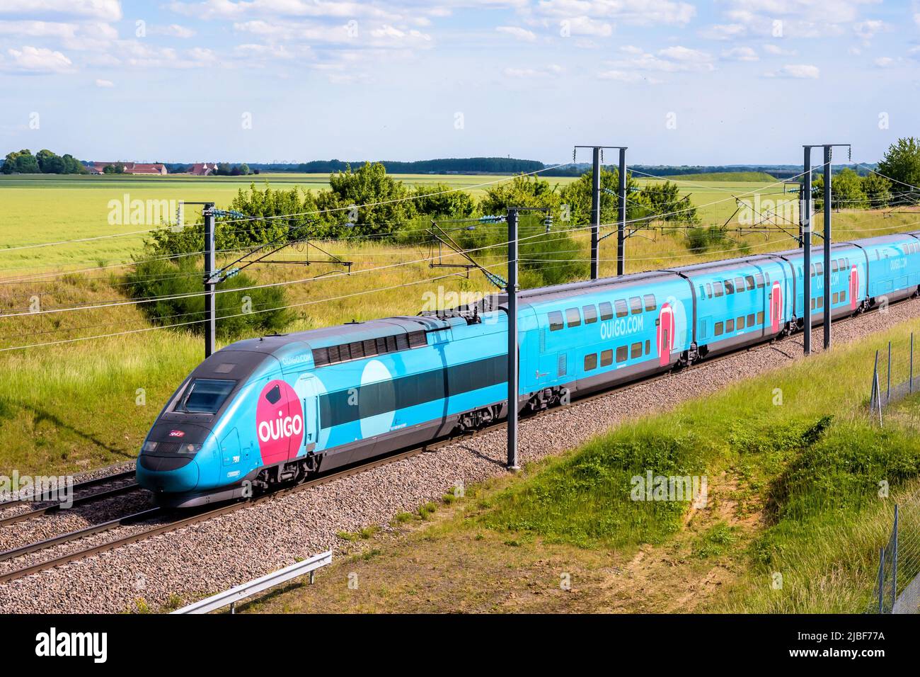 Un tren TGV Duplex Ouigo de alta velocidad de la compañía francesa de trenes SNCF está conduciendo a París en el LGV Sud-Est en el campo. Foto de stock