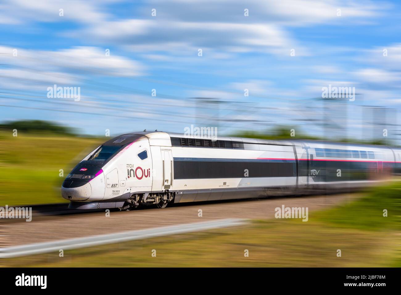Un tren de alta velocidad TGV Euroduplex inOui de la compañía ferroviaria francesa SNCF está conduciendo a toda velocidad en el campo. Foto de stock