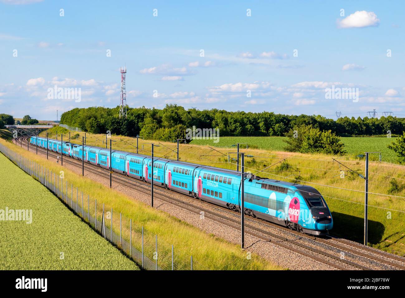 Un tren TGV Duplex Ouigo de alta velocidad de la compañía francesa de trenes SNCF está conduciendo desde París en el LGV Sud-Est en el campo. Foto de stock