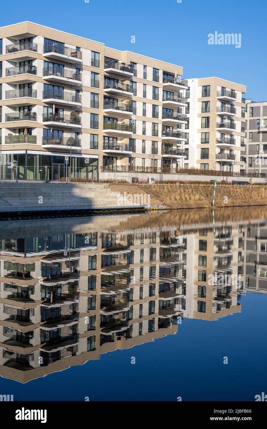 Modernos edificios de apartamentos con una perfecta reflexión en un pequeño canal visto en Berlín, Alemania Foto de stock