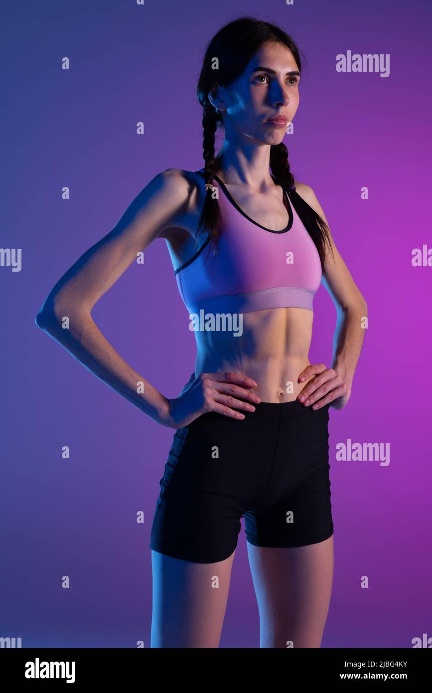 Retrato niña joven de la aptitud, mujer atleta uniforme deportivo posando aislado sobre fondo azul rosa en Deportes, atletismo Fotografía de stock - Alamy