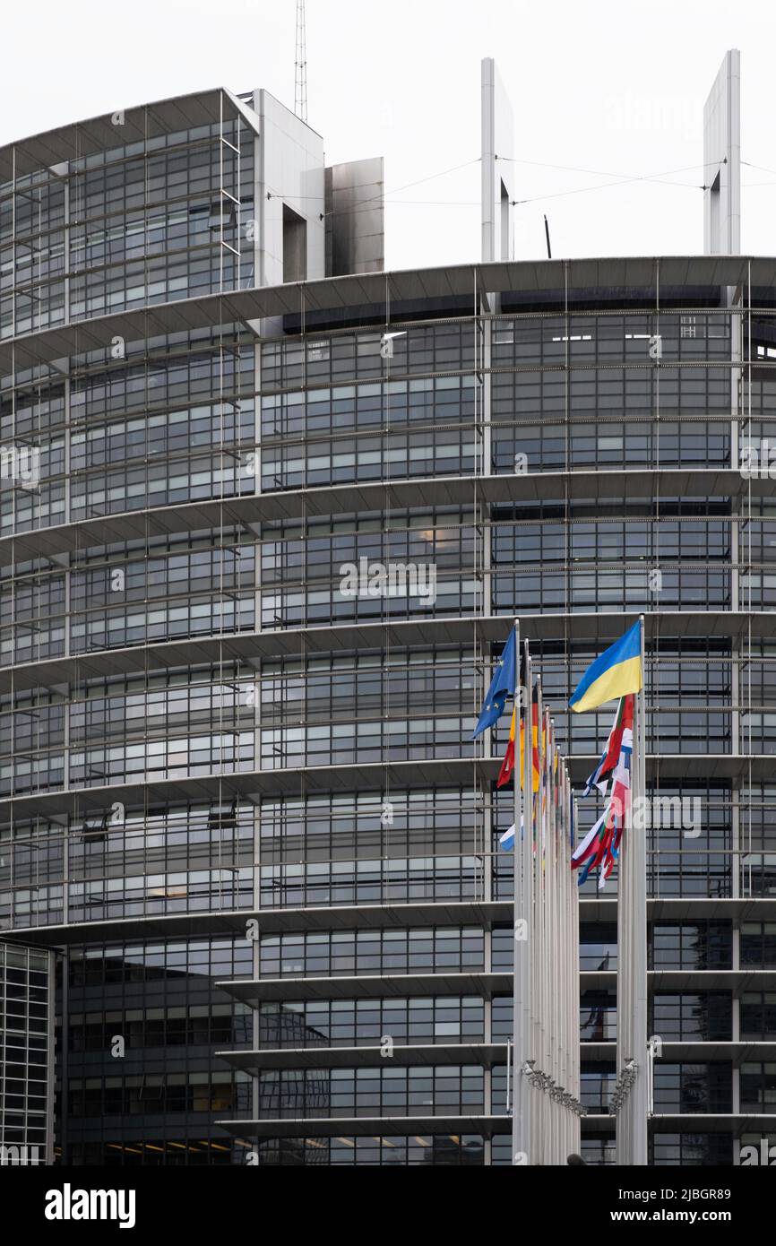 Fachada circular del edificio Louise Weiss del Parlamento Europeo con banderas de los 27 países, incluida la de Ucrania, en Estrasburgo Foto de stock