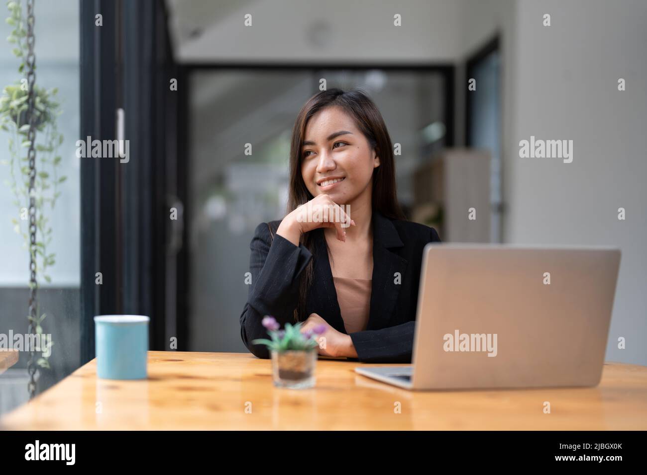 Retrato de la joven mujer asiática independiente en línea que trabaja desde casa con ordenador portátil. Foto de stock