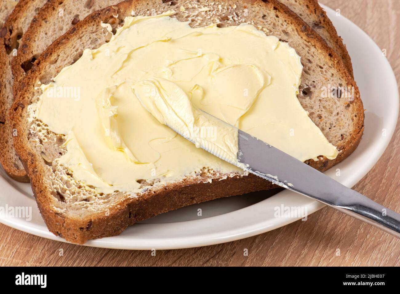 Pan y mantequilla. Un cuchillo que extiende la mantequilla sobre el pan  Fotografía de stock - Alamy