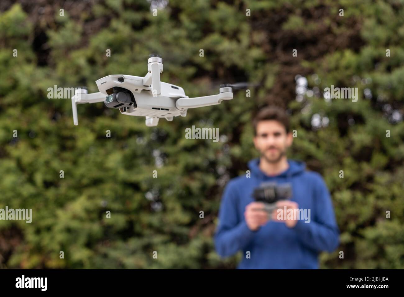 Hombre joven controlando un drone volador al aire libre en el parque  Fotografía de stock - Alamy