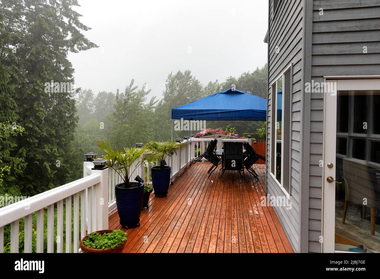 La tormenta fuerte de lluvia cancela la fiesta al aire libre en la terraza del patio trasero Foto de stock