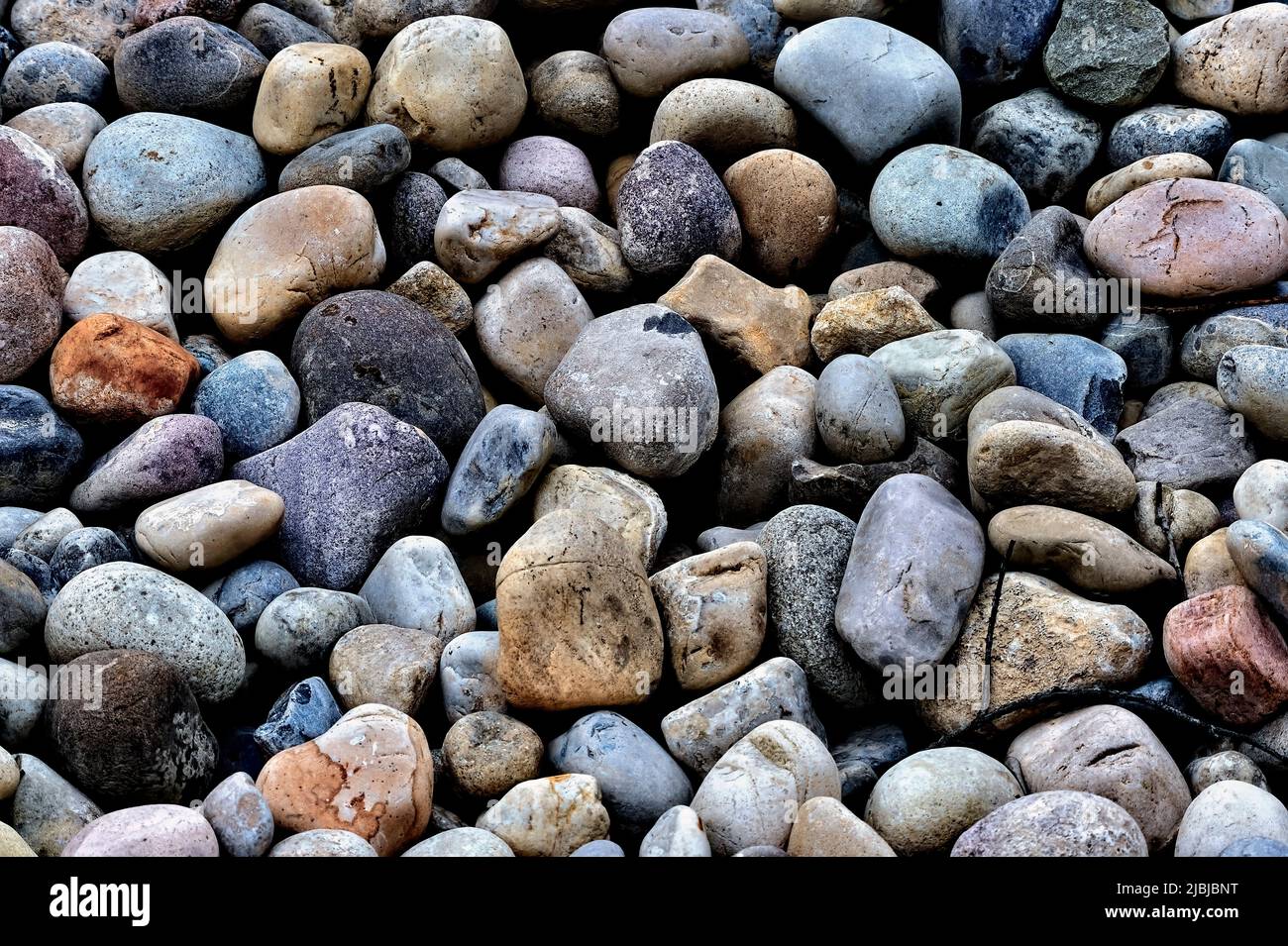 Una imagen de cerca de un montón de coloridas piedras de playa Foto de stock