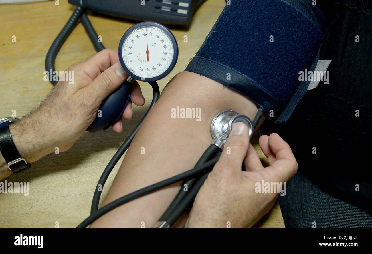 Foto del archivo con fecha 10/09/14 de un médico que comprueba la presión arterial de un paciente, como la mitad del plan de GPS en retirarse antes de que tengan 60 años o cuando llegan a esa edad, una encuesta sugiere. Fecha de emisión: Martes 7 de junio de 2022. Foto de stock