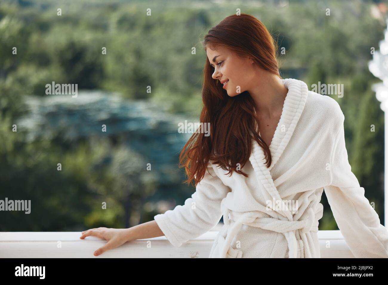 Manchuria Ciego escala Bonita mujer cabello largo en un albornoz blanco que se aloja en el balcón  en un concepto de relajación de hotel Fotografía de stock - Alamy