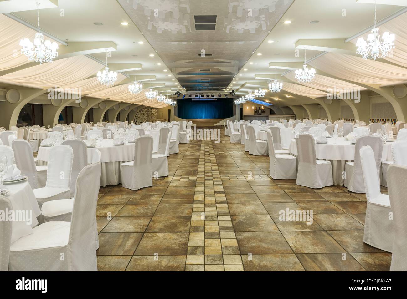 Gran salón de banquetes decorado para eventos sociales con mesas