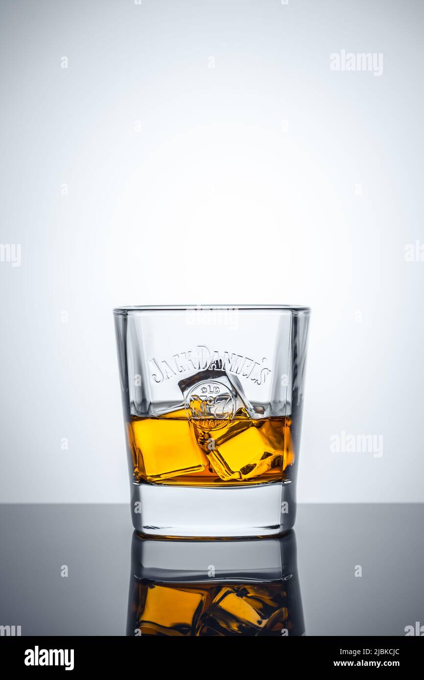 Vaso de whisky escocés y cubitos de hielo sobre fondo blanco. Whisky Jack Daniel's. Marca del whisky americano más vendido del mundo. Illustrati Foto de stock