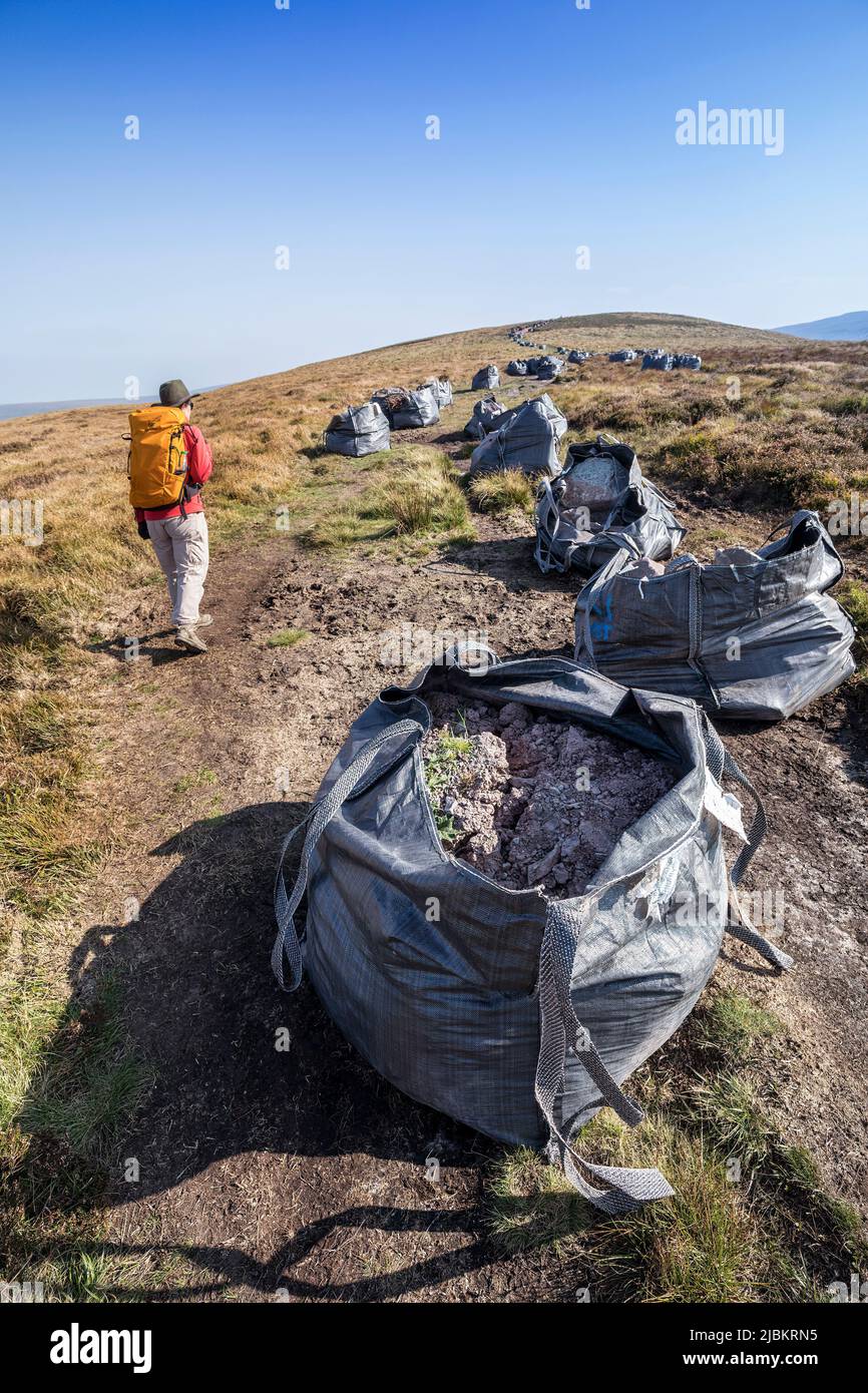 Bolsas de rocas y grava entregadas por helicóptero para trabajos de reparación de senderos, cabeza de la Grwyne Fawr en las Montañas Negras, Brecon Beacons National Par Foto de stock