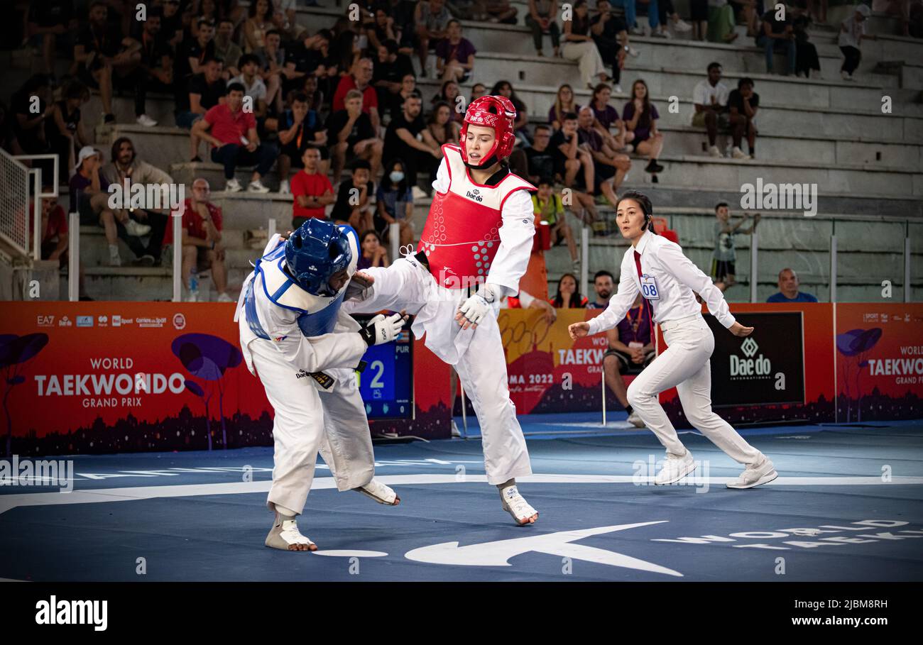 Luchador taekwondo femenino pateando durante el partido. Campeonato Mundial de Taekwondo, Roma, Italia, junio de 4 2022 Foto de stock