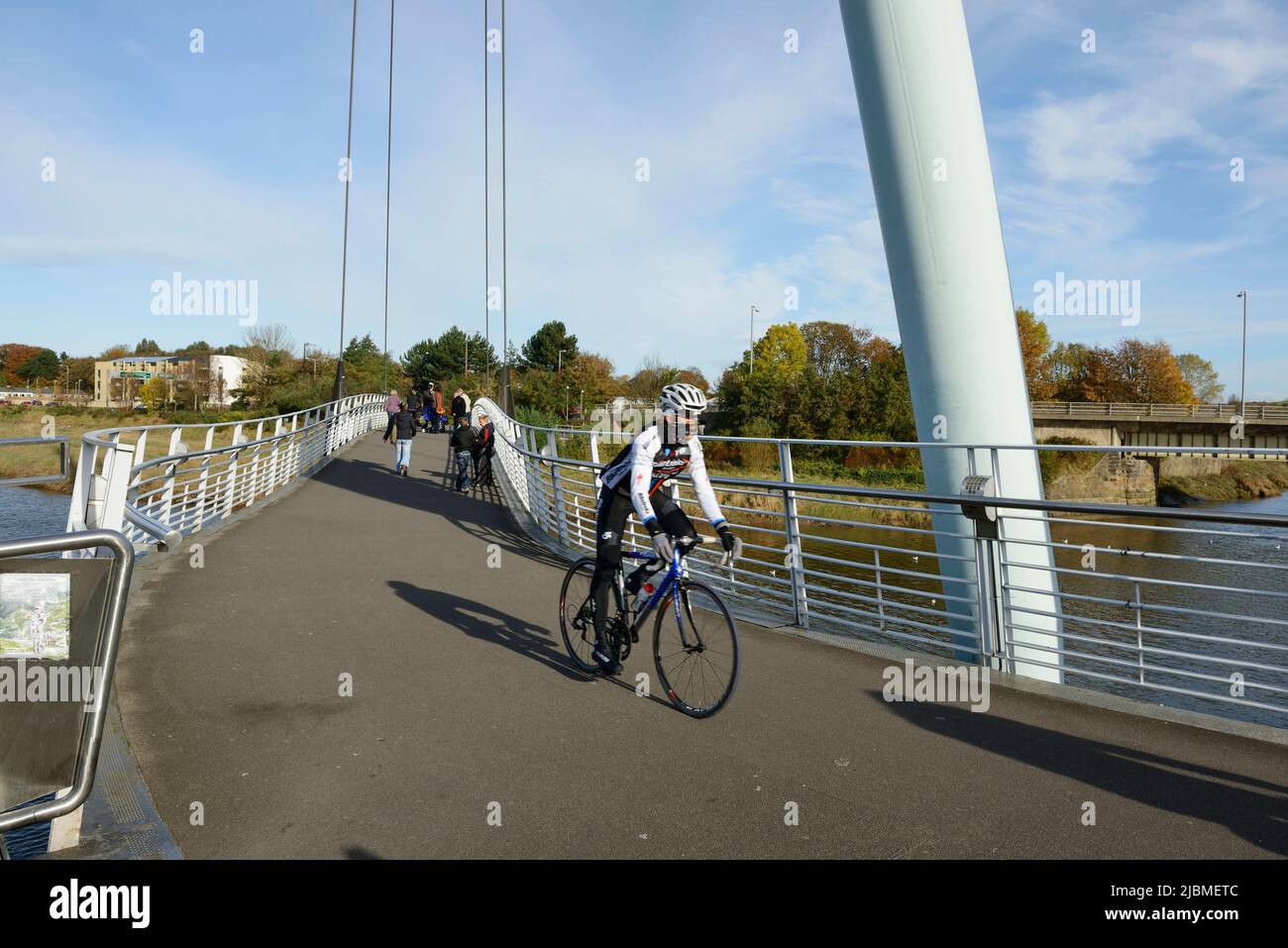 Un ciclista cruza el puente de Lune Millennium sobre el río Lune en el centro de la ciudad de Lancaster, Reino Unido Foto de stock