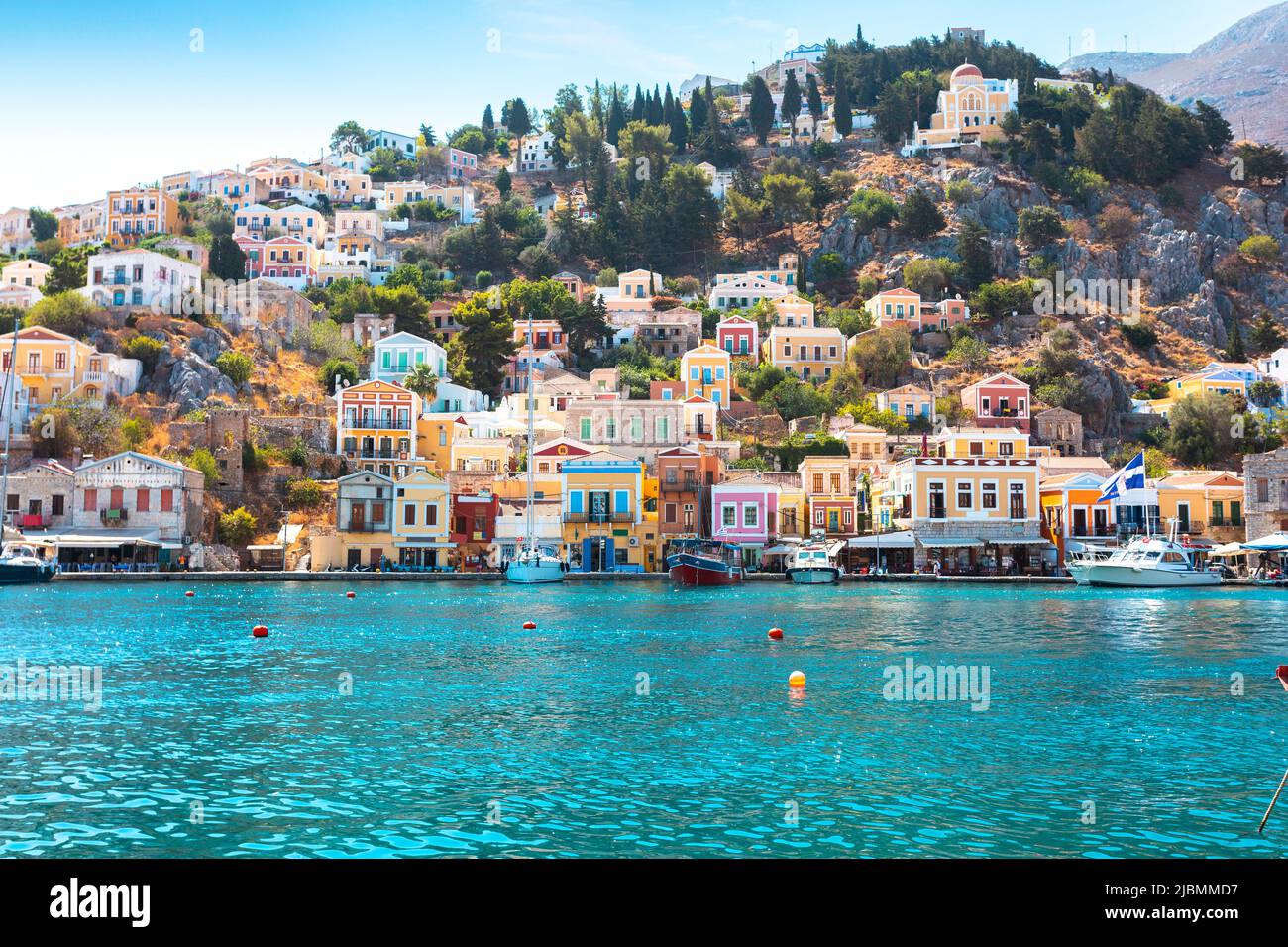Vista sobre el mar griego Symi isla puerto, casas en las colinas de la isla. Foto de stock
