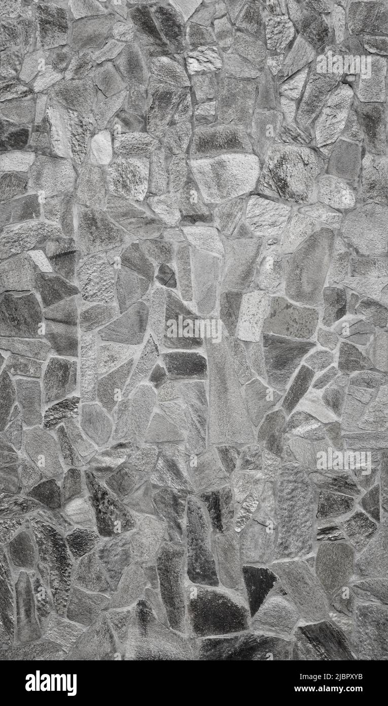 Vista frontal de la pared de piedra hecha de pizarras de piedra erosionadas. Fondo abstracto de fotograma completo de alta resolución con textura en blanco y negro. Foto de stock