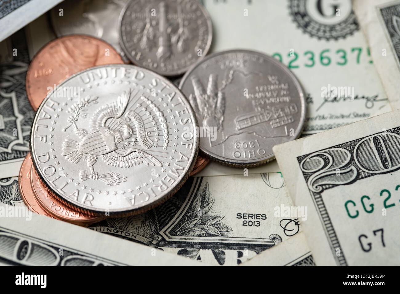 Moneda de medio dólar en monedas más pequeñas rodeadas de billetes en dólares. Economía Y moneda DE EE.UU. Montón de dinero en efectivo Foto de stock