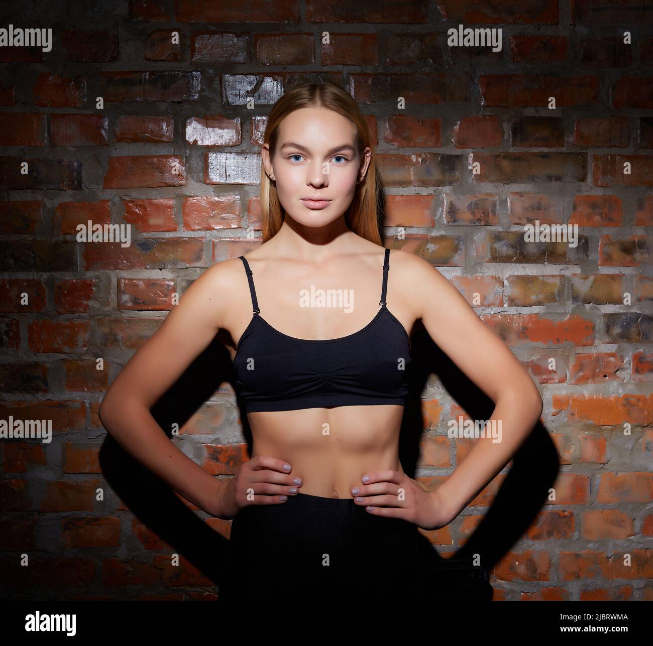concepto de estilo de vida deportivo y de yoga. Joven en forma bonita vestida con ropa deportiva se contra la pared de ladrillo Fotografía de stock - Alamy