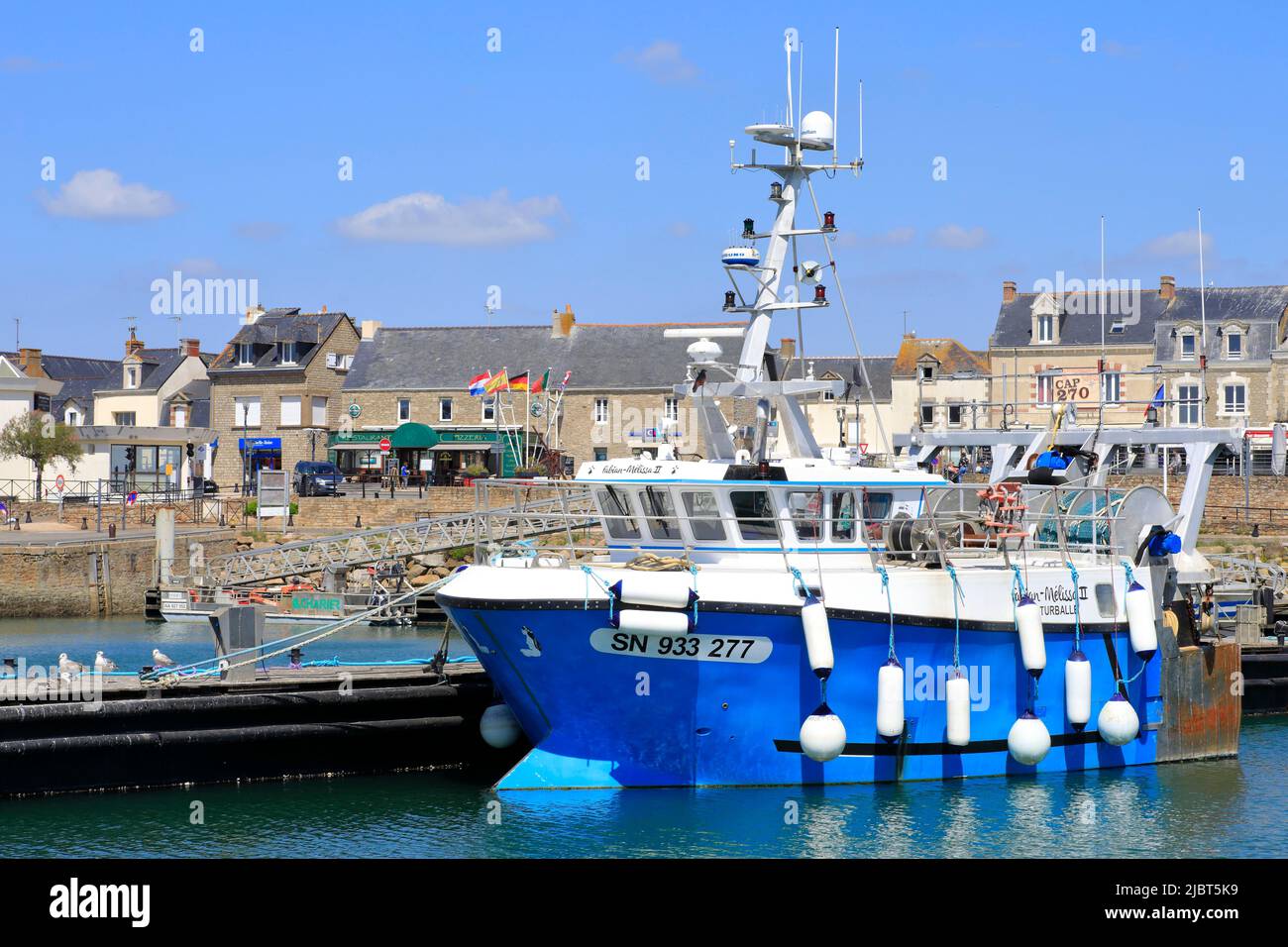 Francia, Loira Atlántico, La Turballe, arrastre en el puerto con el pueblo en el fondo Foto de stock