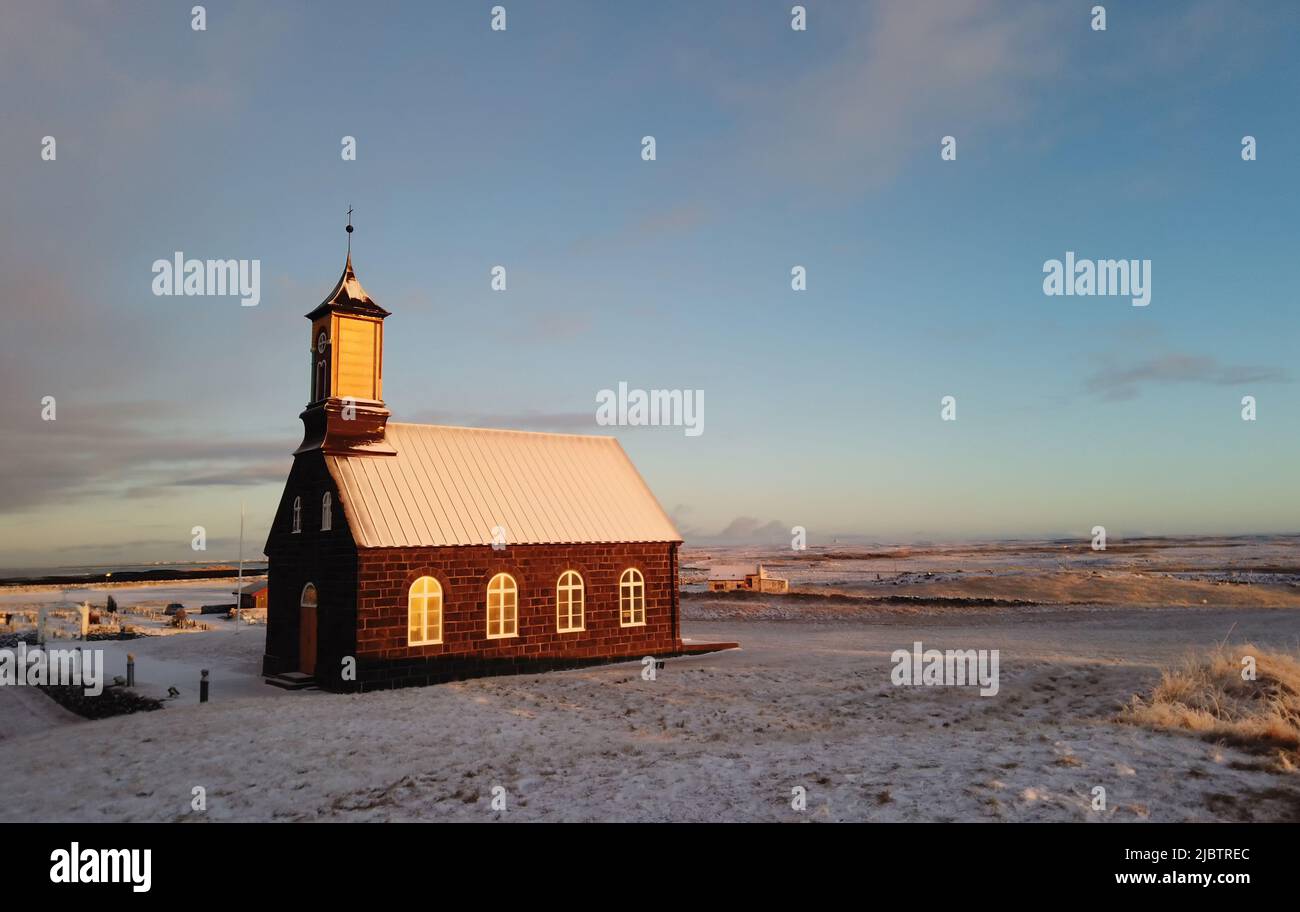 Hvalsneskirkja iglesia situada cerca de la aldea de Sandgerdi en Islandia en invierno al atardecer. Foto de stock