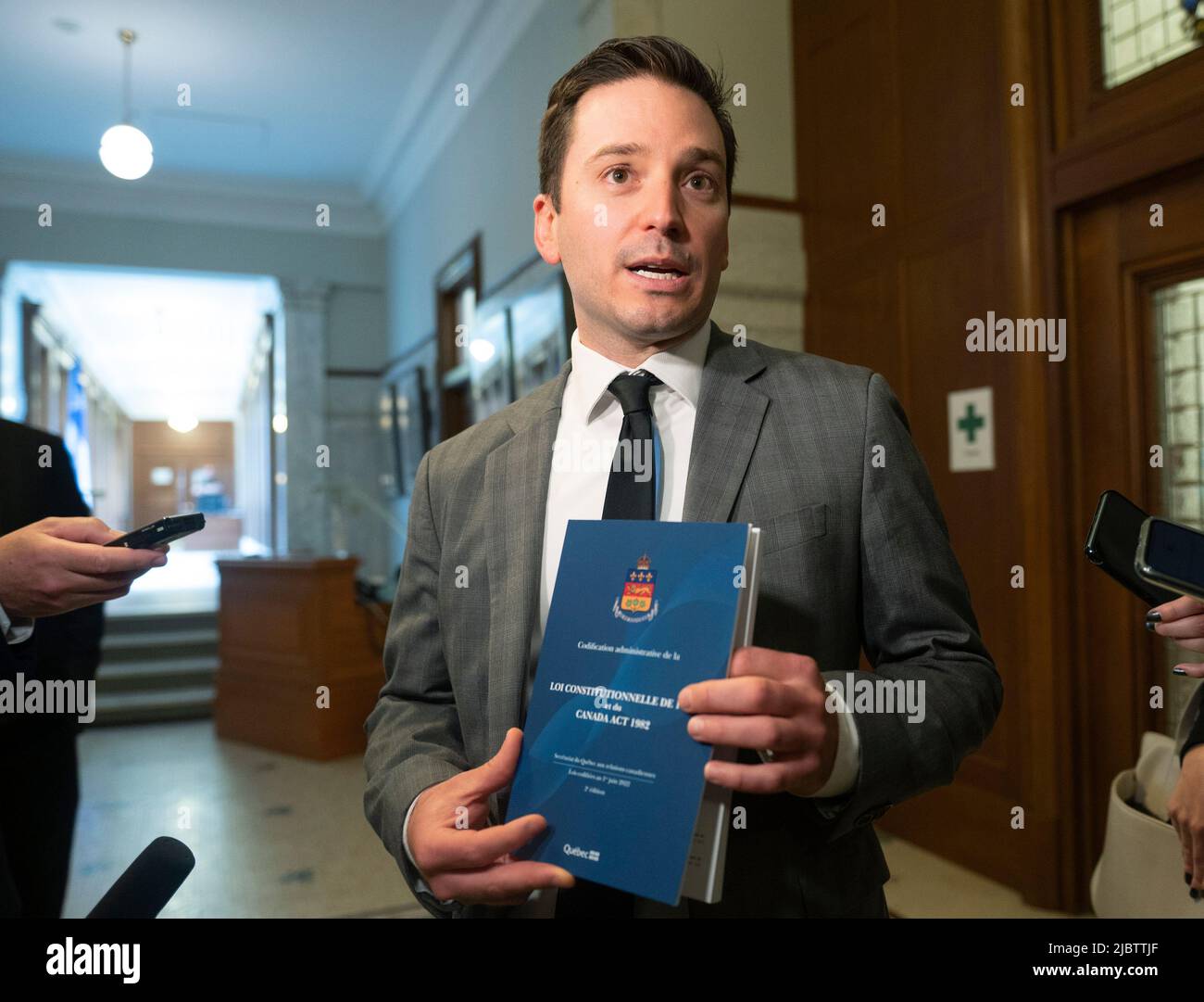 Ciudad de Quebec. Canadá, 8 de junio de 2022, el Ministro de Justicia y  Ministro de Lengua Francesa de Quebec, Simon Jolin-Barrette, tiene un libro  que contiene la constitución canadiense de 1867