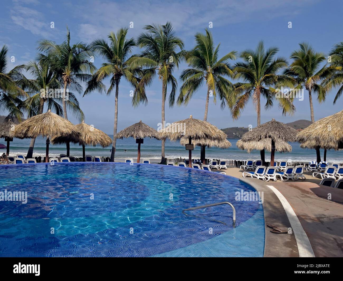 Hotel frente a la playa con piscina y palapas en La Playa Ropa en Zihuatanejo, México Foto de stock
