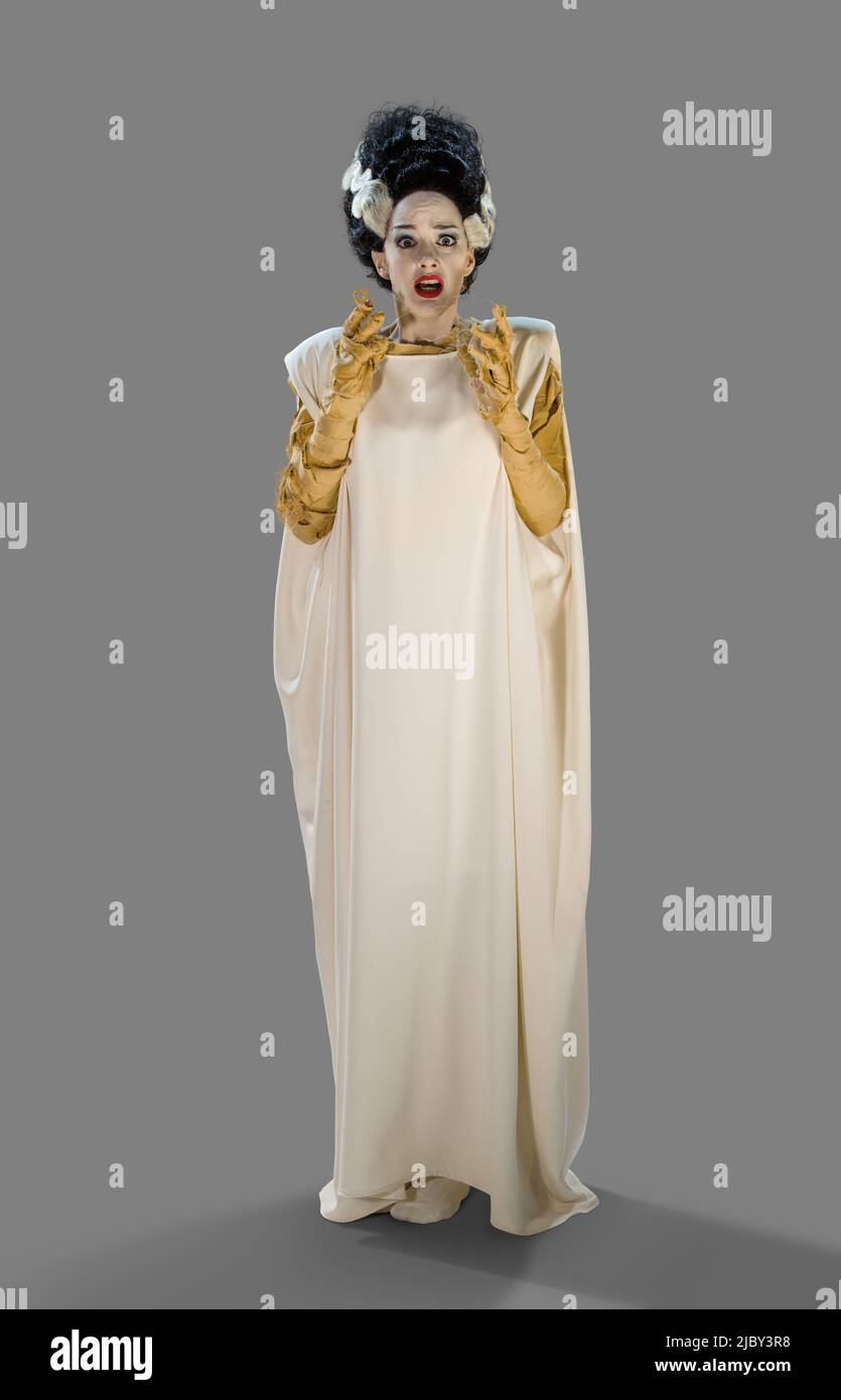 Retrato de una mujer en una novia de Frankenstein disfraz de Halloween  mirando en la cámara asustada, contra fondo gris Fotografía de stock - Alamy