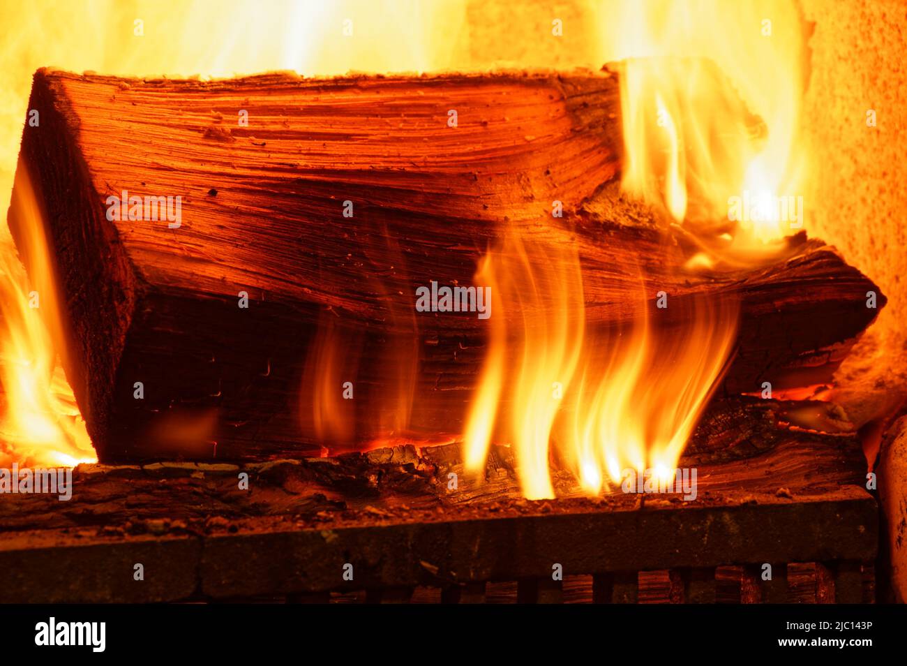 Un fuego abierto proporciona calor invernal, sus llamas bailando sobre la madera en llamas Foto de stock