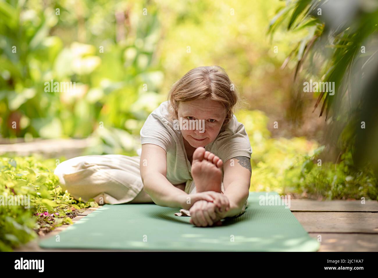 Mujer madura practicando yoga pose en casa Foto de stock