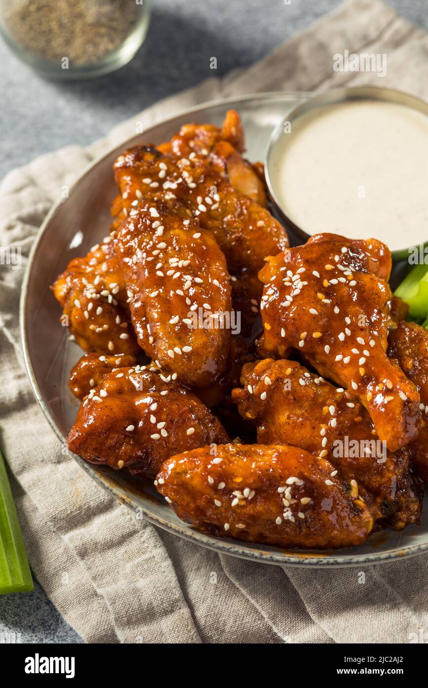 Alitas de pollo con miel de Sriracha caseras con sésamo y rancho Foto de stock