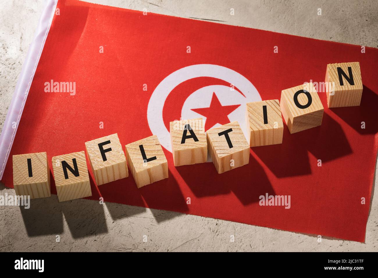 Bandera de Túnez y cubos de madera con texto, un concepto sobre el tema de la inflación en el país Foto de stock