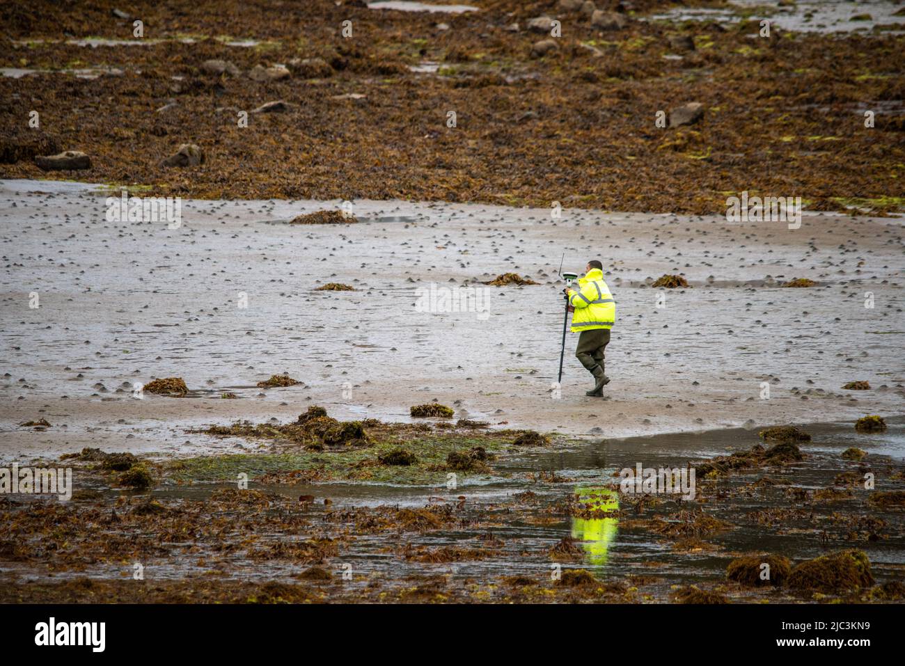 Hombre en chaqueta de alta visibilidad midiendo agua Foto de stock