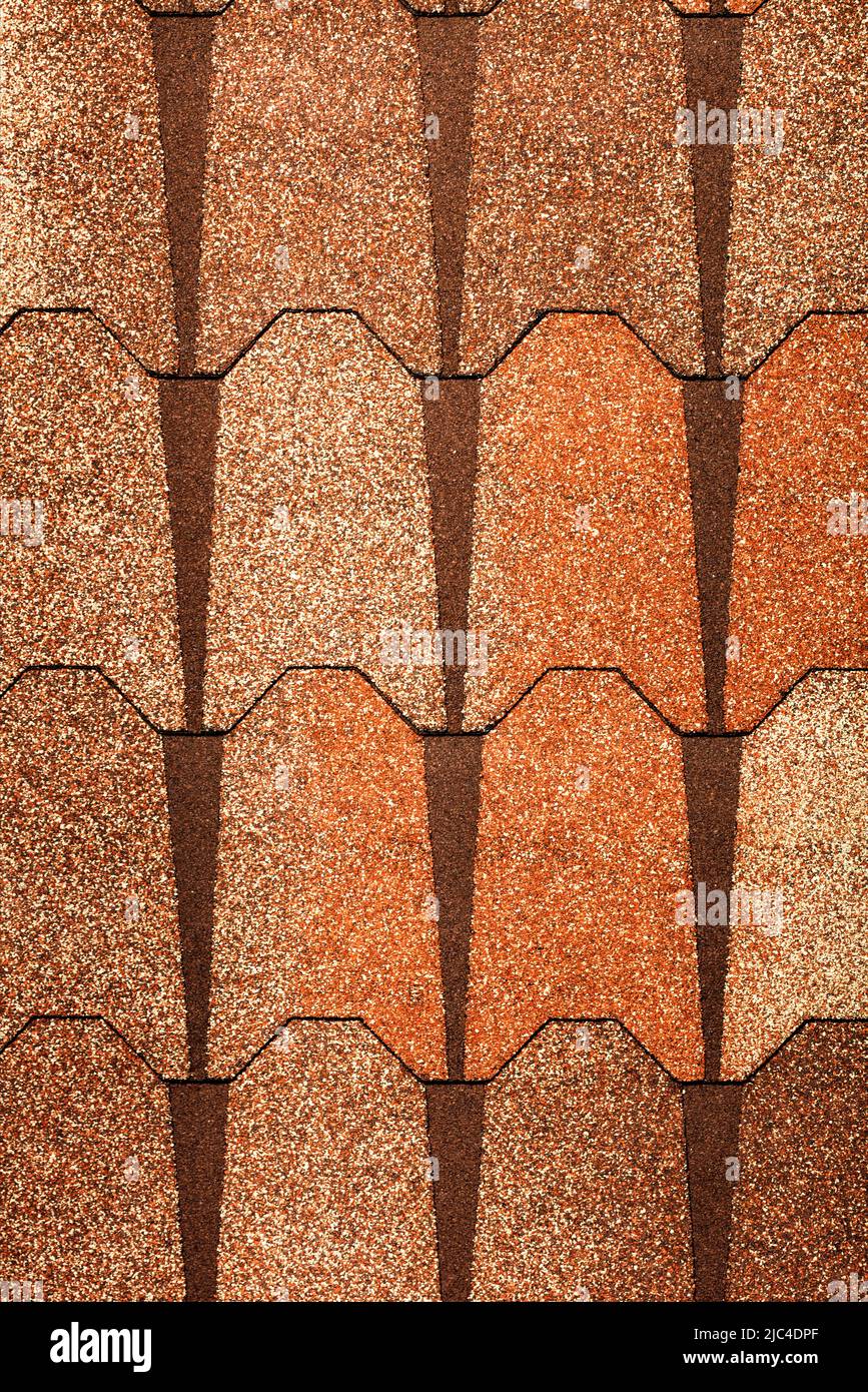 Fondo y textura de tejas bituminosas marrones con revestimiento hidrófilo de piedra. Imagen vertical. Espacio de copia. Foto de stock