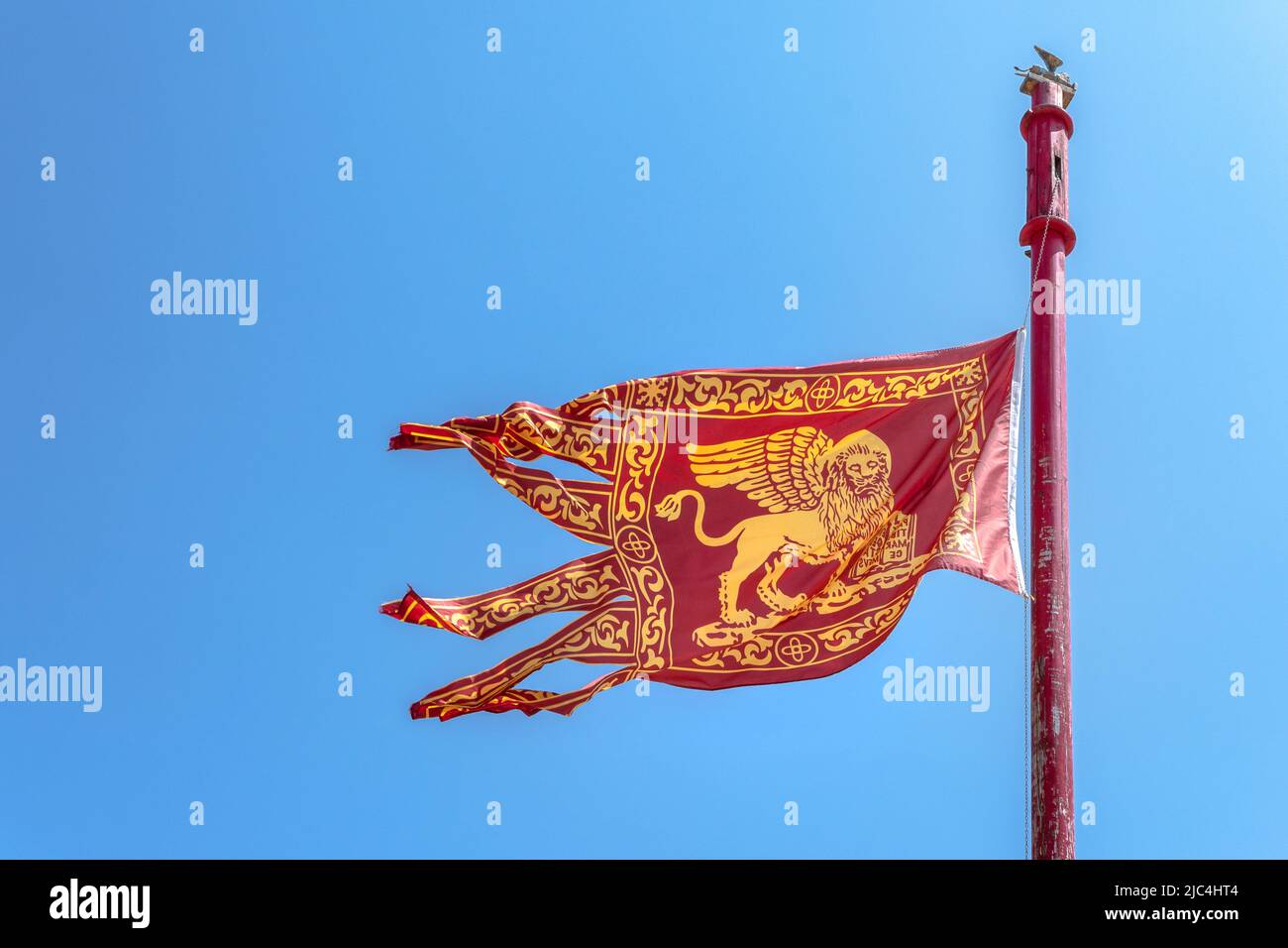 Venecia, ITALIA - 22 de julio de 2020. La bandera veneciana vuela en el cielo azul. Concepto de viaje y patriota italiano. Espacio de copia. Foto de stock