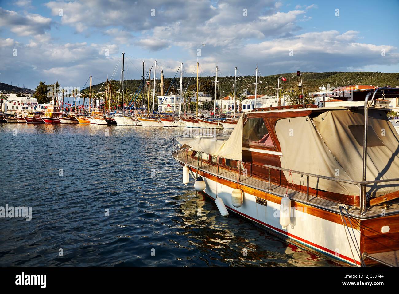 Vista de la playa de Bodrum desde el Paseo Marítimo. Barcos de vela, yates en el mar Egeo con casas blancas tradicionales en las colinas en Bodrum ciudad portuaria de Turquía Foto de stock