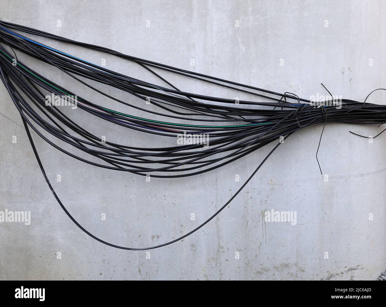 Un montón de cables eléctricos y de comunicación, cables en el polo, el caos de cables y cables en un polo eléctrico. Foto de stock