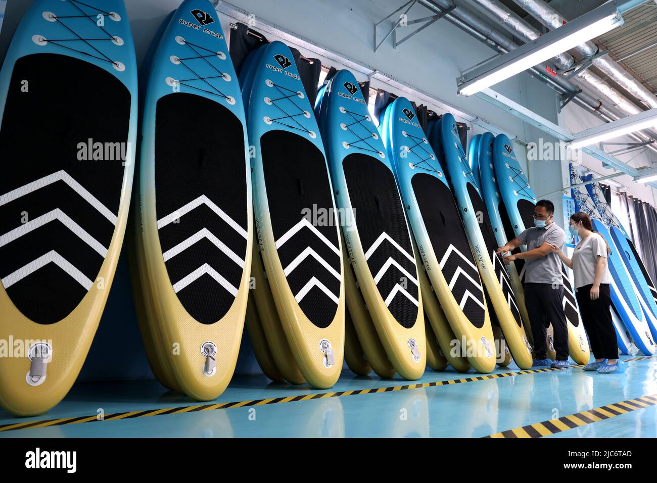 BINZHOU, CHINA - 6 DE JUNIO de 2022 - Un trabajador produce tablas de surf  para pedidos en el extranjero en un taller de producción de tablas de surf  en Binzhou, Provincia